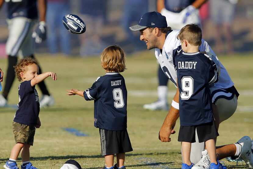 Dallas Cowboys quarterback Tony Romo (9) plays catch with his kids Hawkins Romo (right) and...