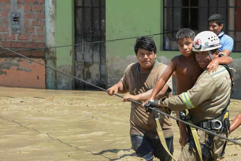 Trabajadores de rescate ayudan a los residentes locales de la ciudad de Huarmey, a 187...