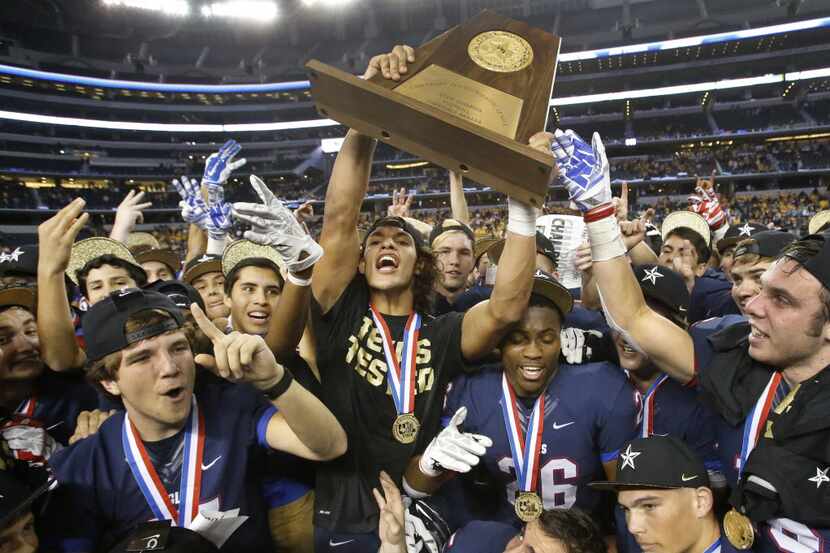 Allen linebacker Jakob Yandell holds the championship trophy high with his teammates after...