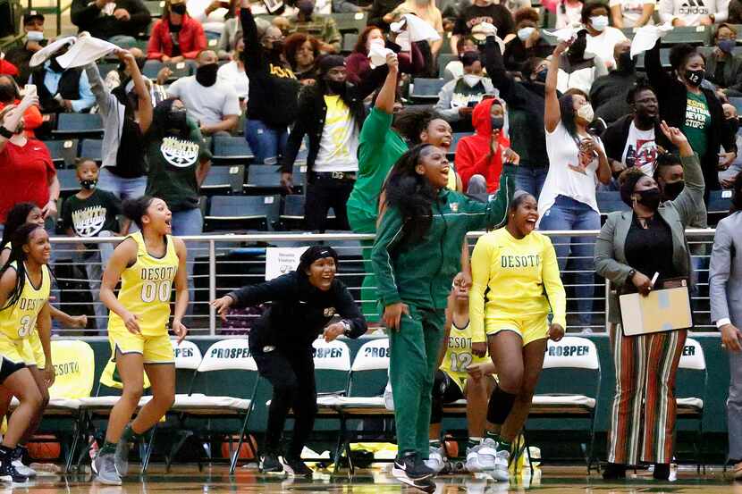 The DeSoto High School bench celebrates a basket as they pull away near the end of the game...