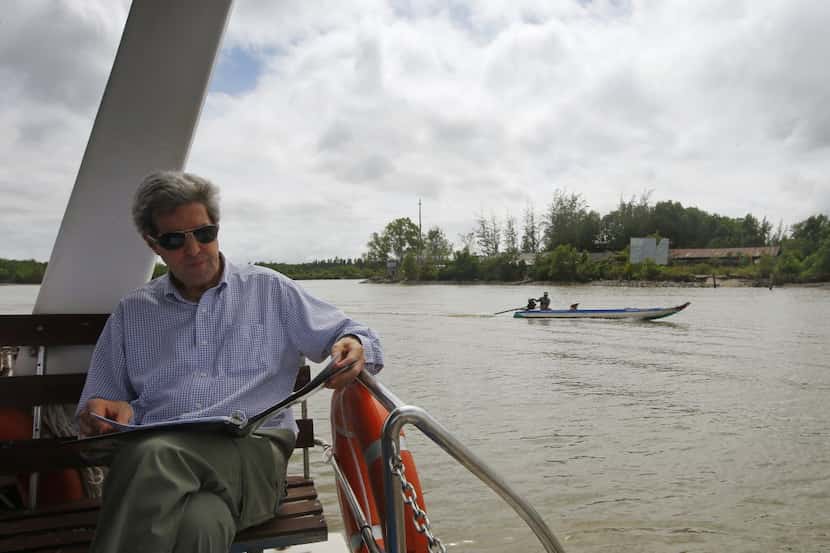 U.S. Secretary of State John Kerry reads over a speech on a boat on the Mekong River Delta...