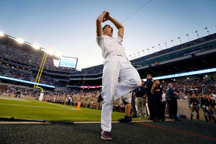 Gavin Suel, a junior yell leader, leads a cheer before halftime of the Texas A&M Aggies...