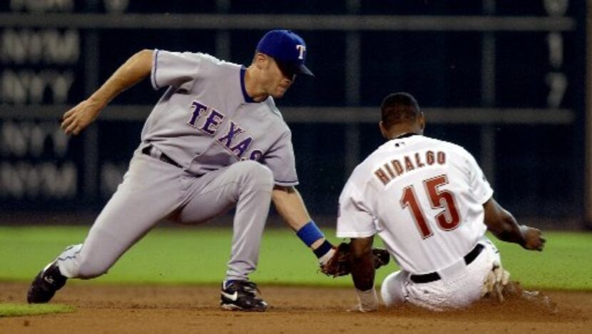 Texas Rangers second baseman Michael Young, left, tags out Houston Astros' Richard Hidalgo...