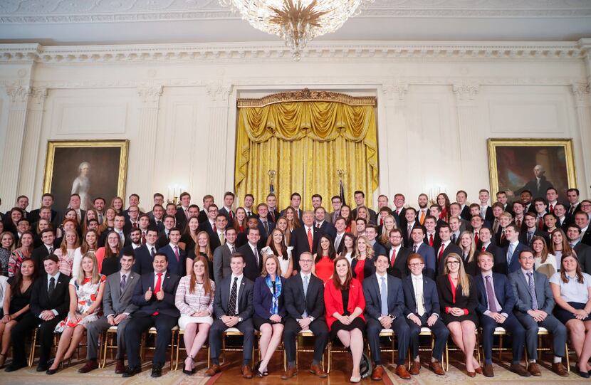 President Donald Trump poses for a photo with outgoing White House interns in the East Room...