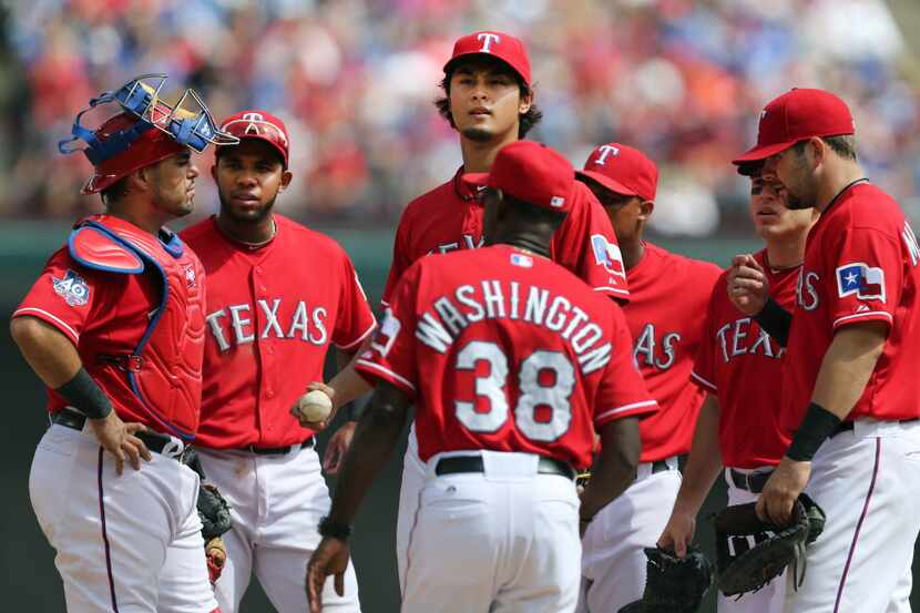 Texas starting pitcher Yu Darvish waits on the mound as manager Ron Washington comes out to...