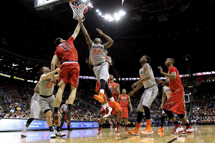 Marcus Smart #33 of the Oklahoma State Cowboys battles Dejan Kravic #11 of the Texas Tech...