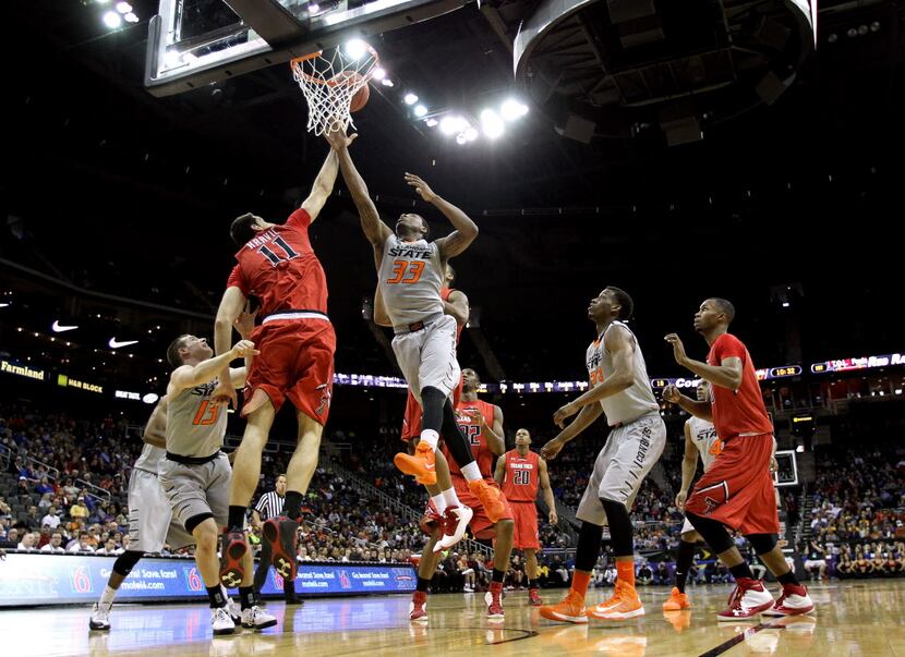 Marcus Smart #33 of the Oklahoma State Cowboys battles Dejan Kravic #11 of the Texas Tech...