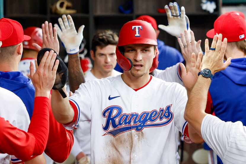 Texas Rangers shortstop Corey Seager (5) high-fives his teammates in the dugout after...