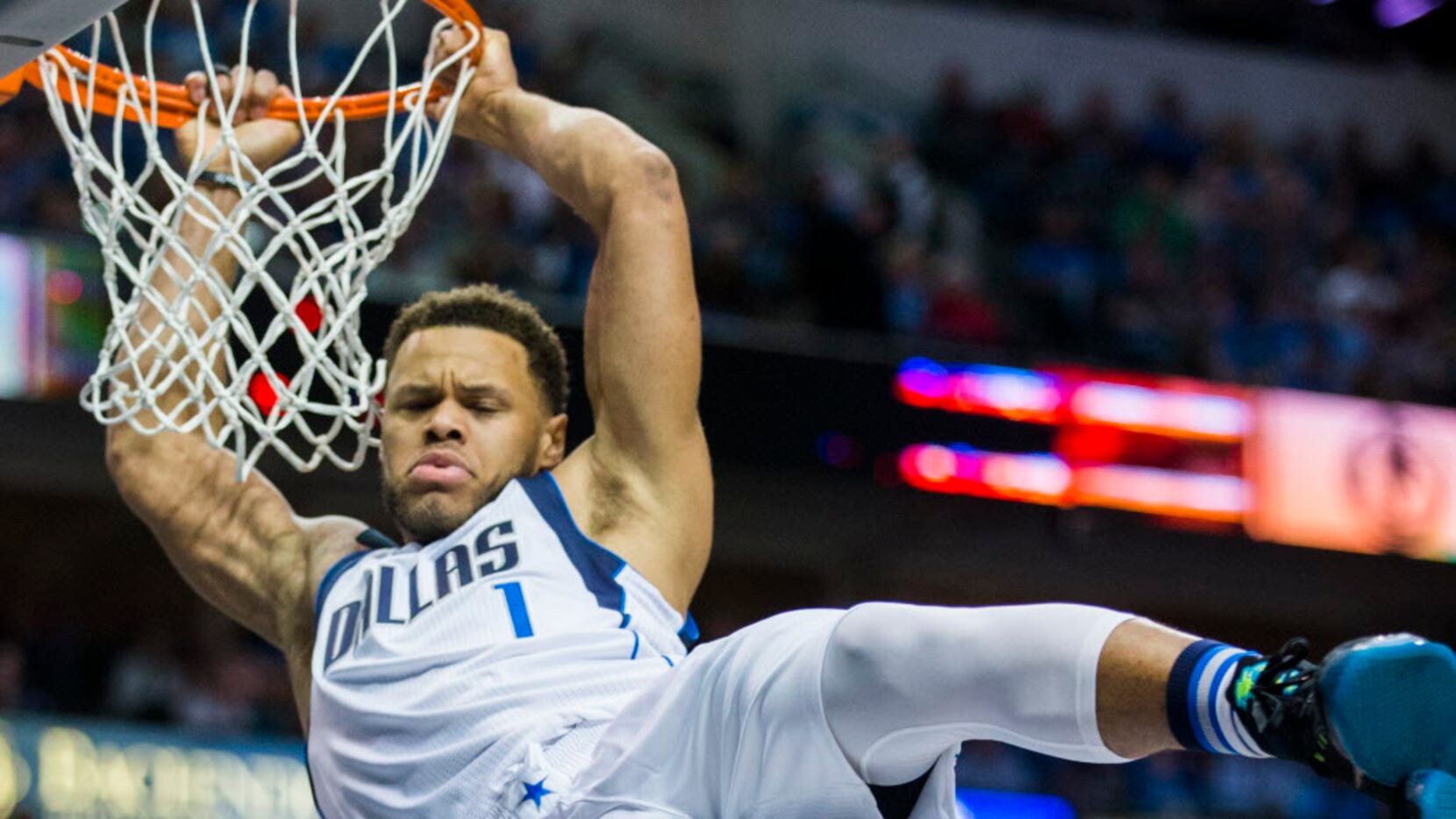 Dallas Mavericks guard Justin Anderson (1) hangs on the rim after dunking the ball during...