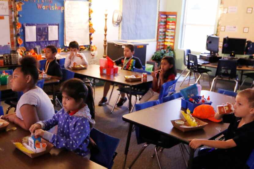 Kayla Claybome, 8, (from left), Gabriela Castillo, 7, and Aidan Hackworth, 7, eat breakfast...