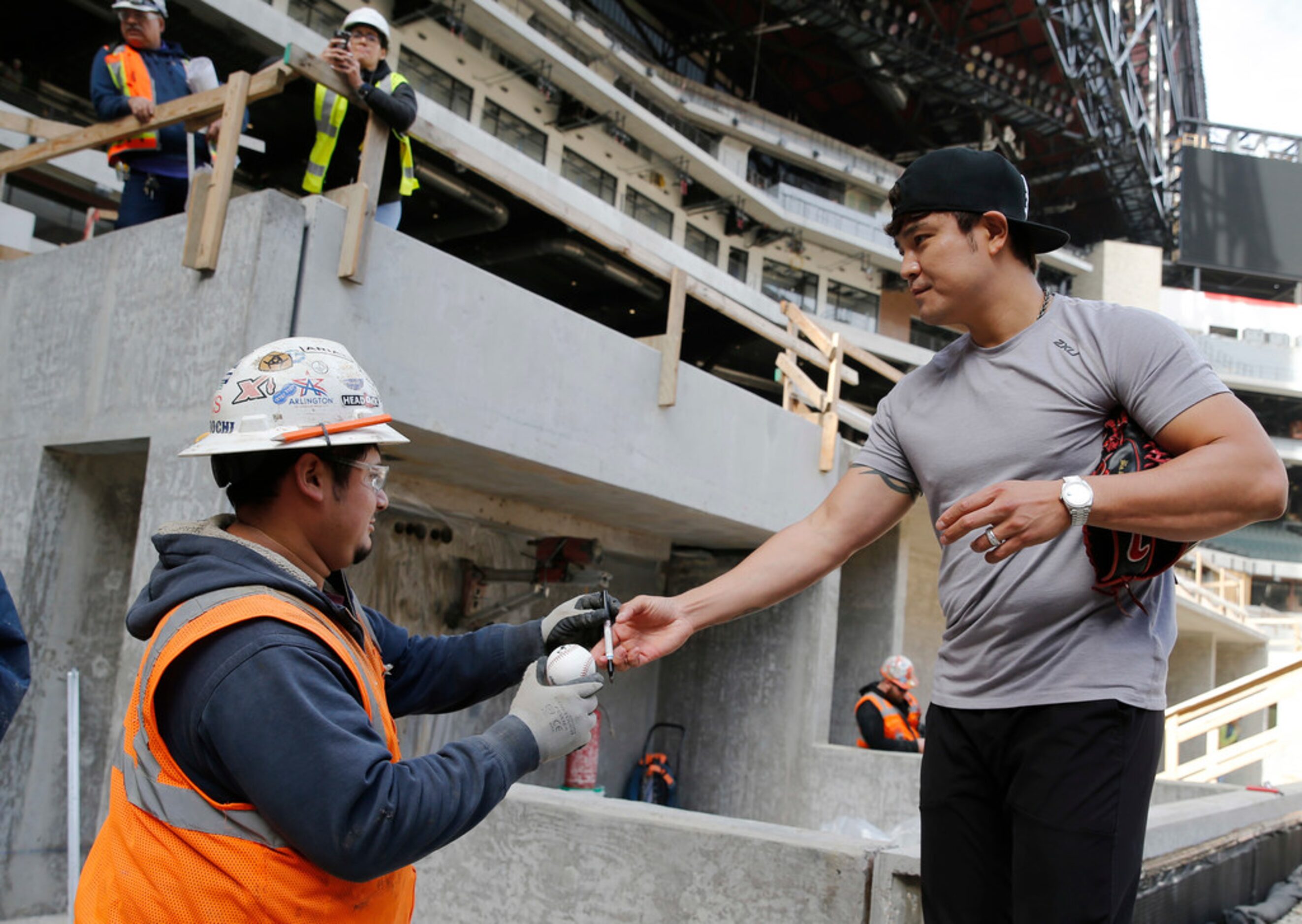 Texas Rangers Shin-Soo Choo gives a signed baseball to Gerson Moreira from the construction...