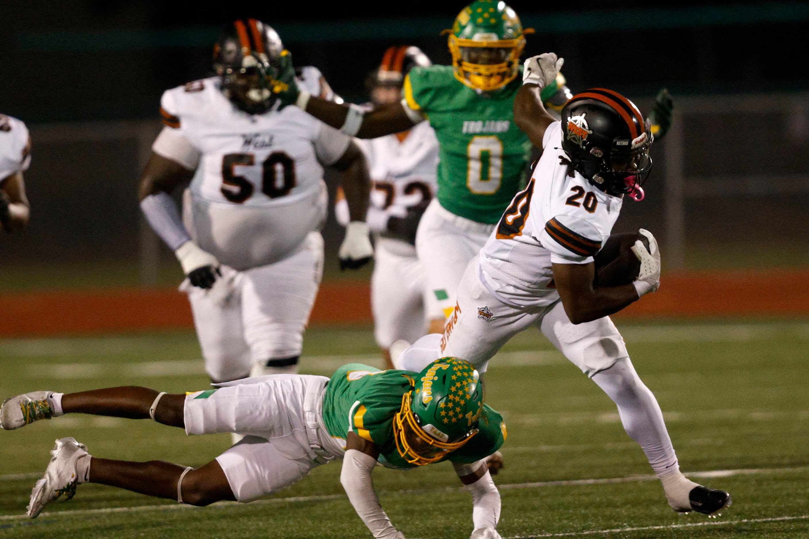 West Mesquite's Kamari Carter (20) is tackled by Newman Smith's LaMond Allison (28), bottom,...