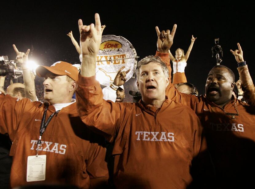 FILE - In this Jan. 4, 2006, file photo, Texas head coach Mack Brown, center, does the...