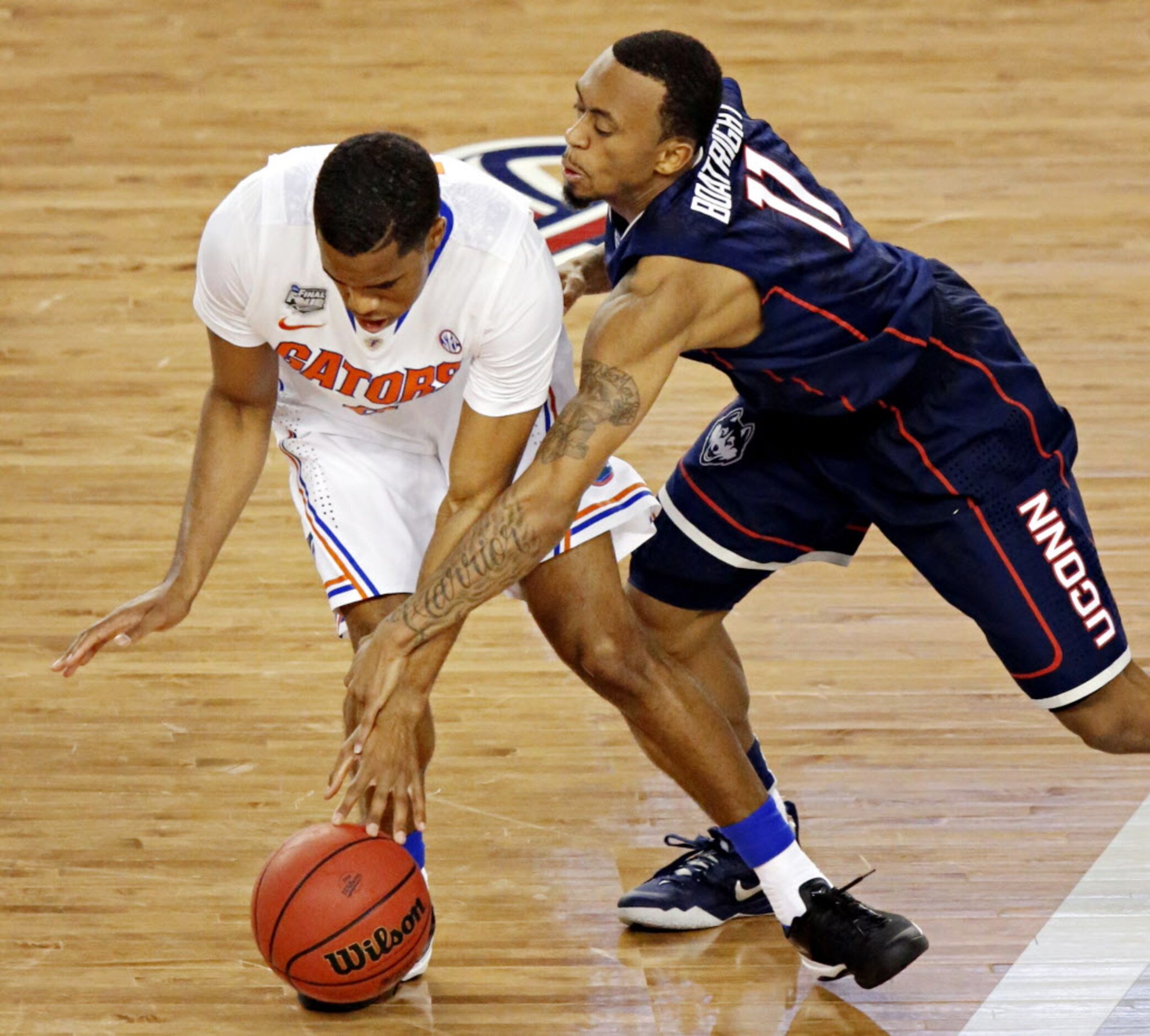 Connecticut Huskies guard Ryan Boatright (11) and Florida Gators guard Kasey Hill battle for...