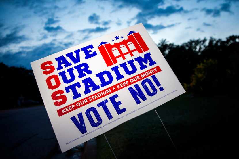 Yard signs expressing opposition to a proposal to build a $1 billion retractable-roof...