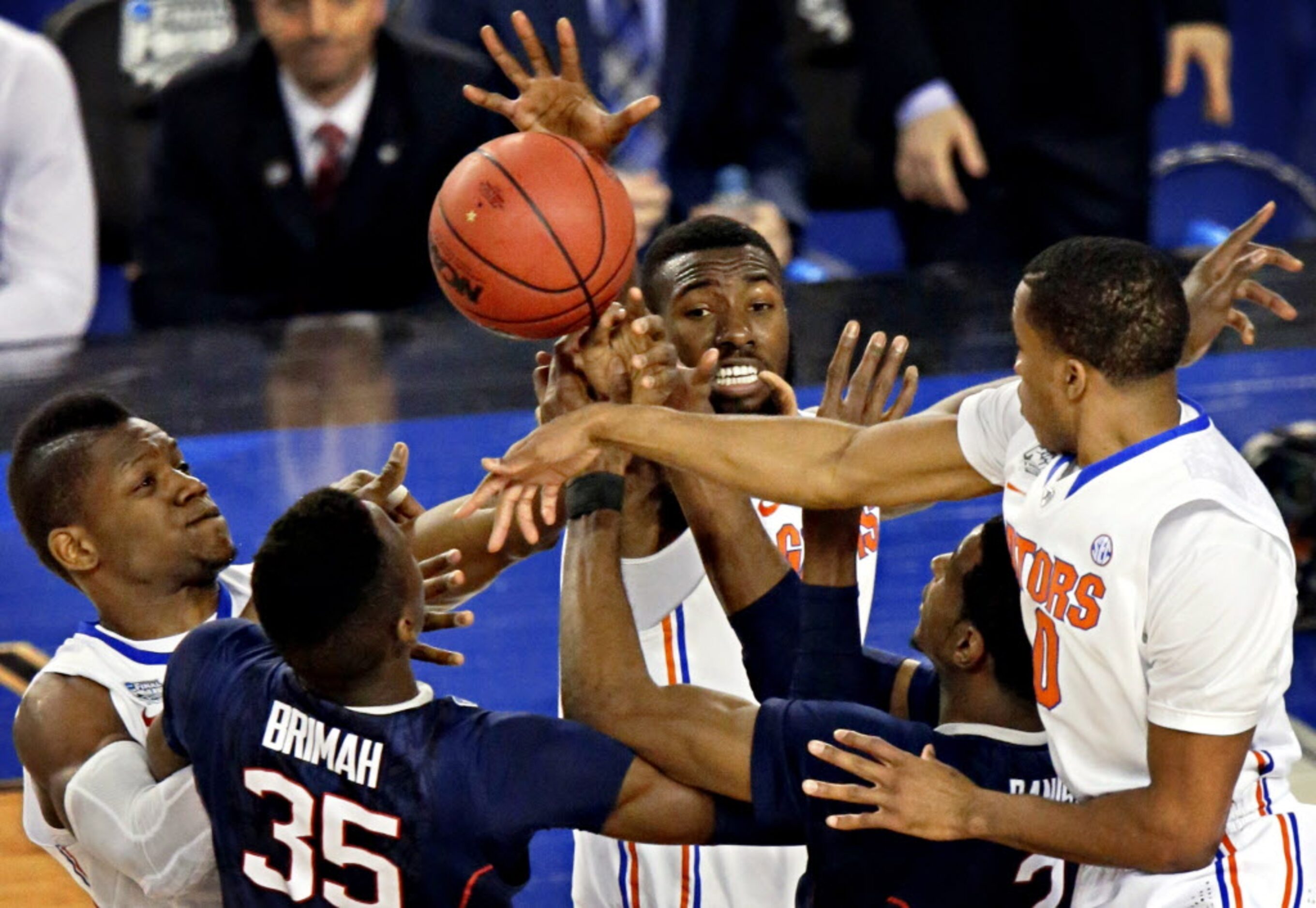 A bevy of Connecticut Huskies and Florida Gators players battle for a rebound during the...