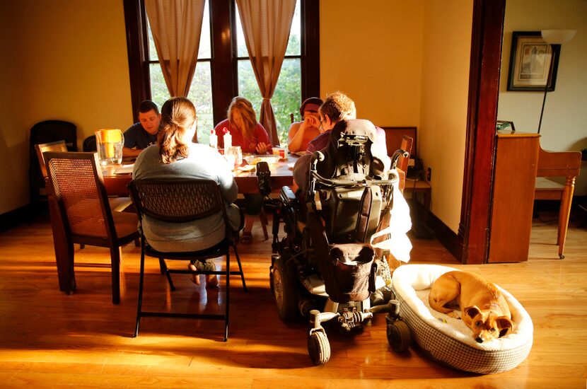 The Rev. Justin Hancock (right) and his wife, Lisa, join visitor Matt Harrell (facing, left)...