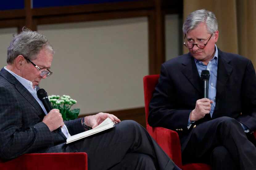 Former President George W. Bush reads as Jon Meacham, author of a new biography of former...