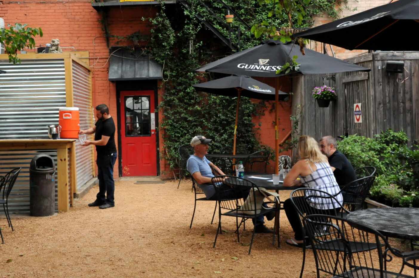 Patrons enjoy the back patio at Eight Bells Alehouse in Expo Park Dallas, TX on August 29,...
