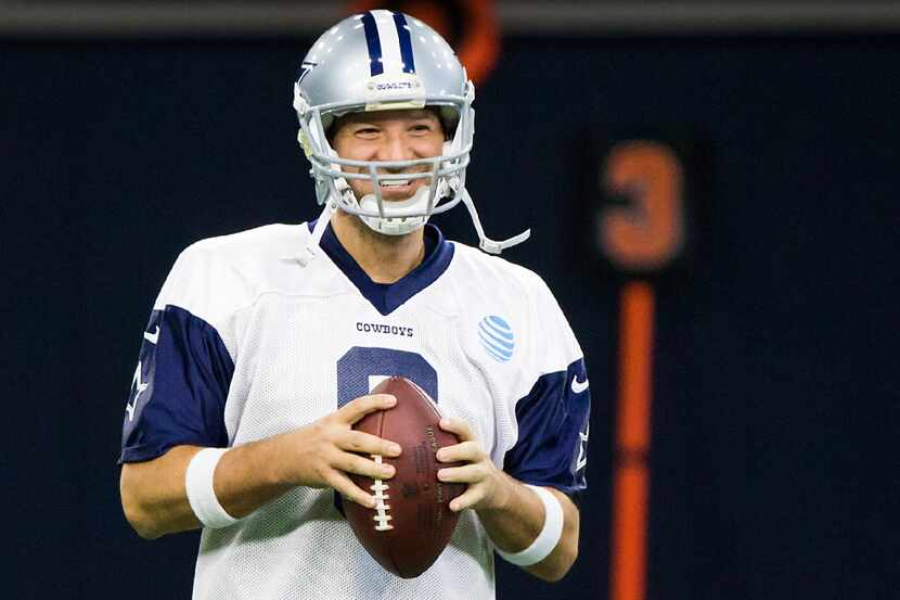 Dallas Cowboys quarterback Tony Romo smiles before throwing his first pass during the team's...