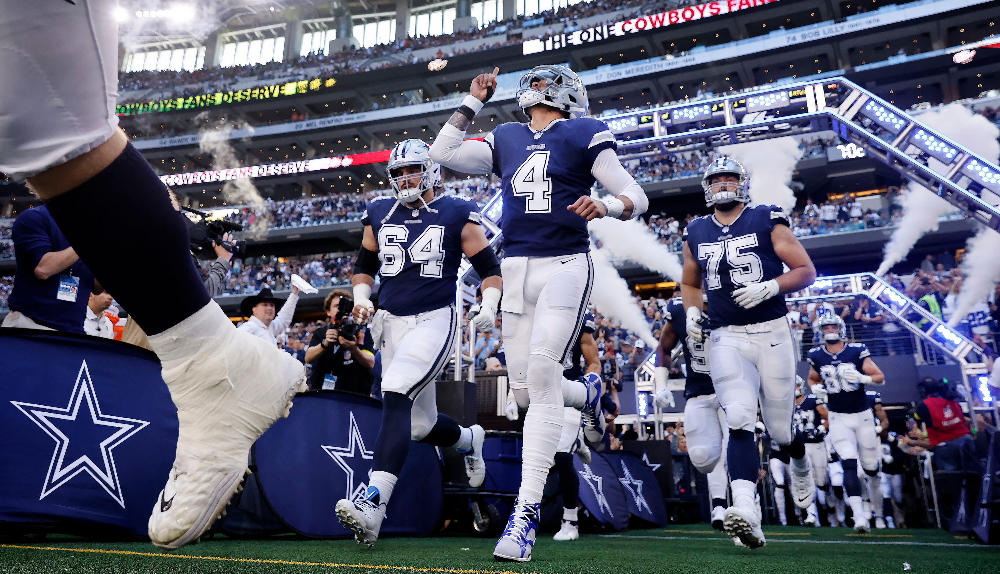 Dallas Cowboys quarterback Dak Prescott (4) points skyward as he ands teammates enter AT&T...