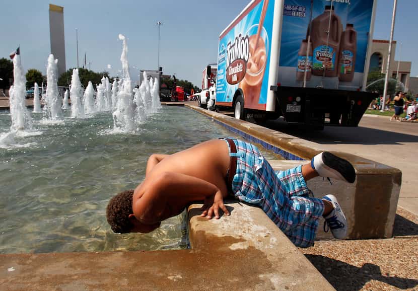 8-year-old Coby Vandergriff plunges his head into a fountain to cool off on Aug. 4, 2011 in...
