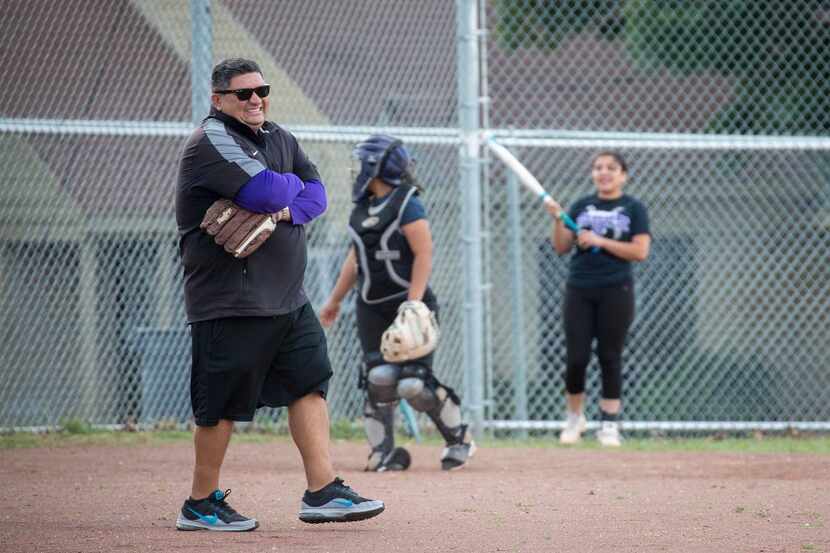 Chris Castillo works with his team during softball practice at Sunset High School on...