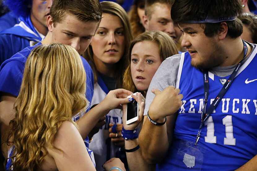 Kentucky Wildcats students pass around a smartphone before their NCAA Final Four semifinal...