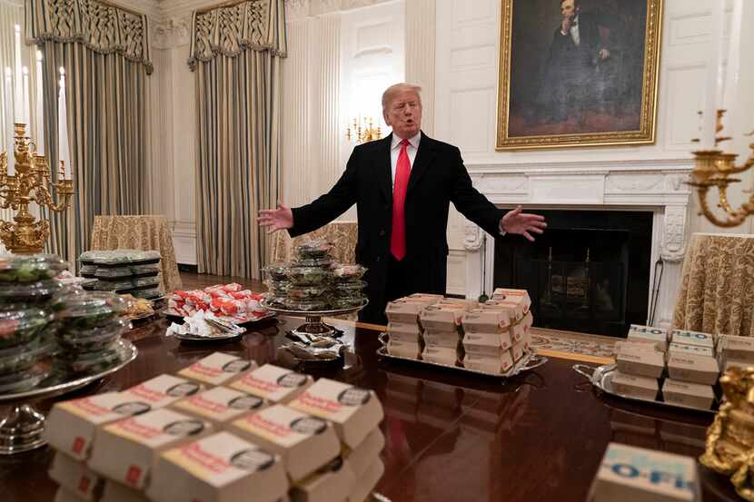 U.S President Donald Trump presents fast food to be served to the Clemson Tigers football...