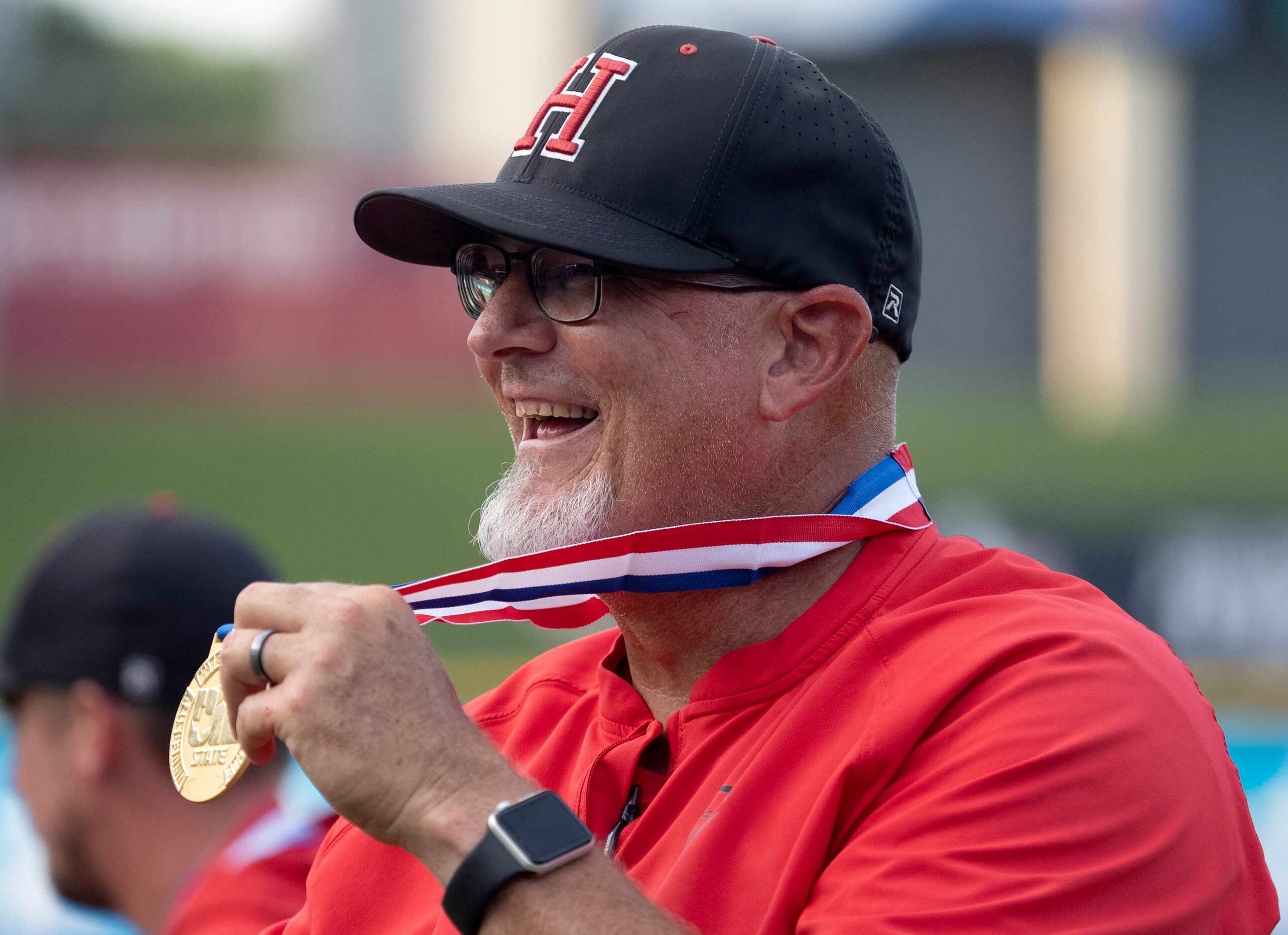 Rockwall-Heath head coach, Greg Harvey, holds up his state medal after the Hawks defeated...