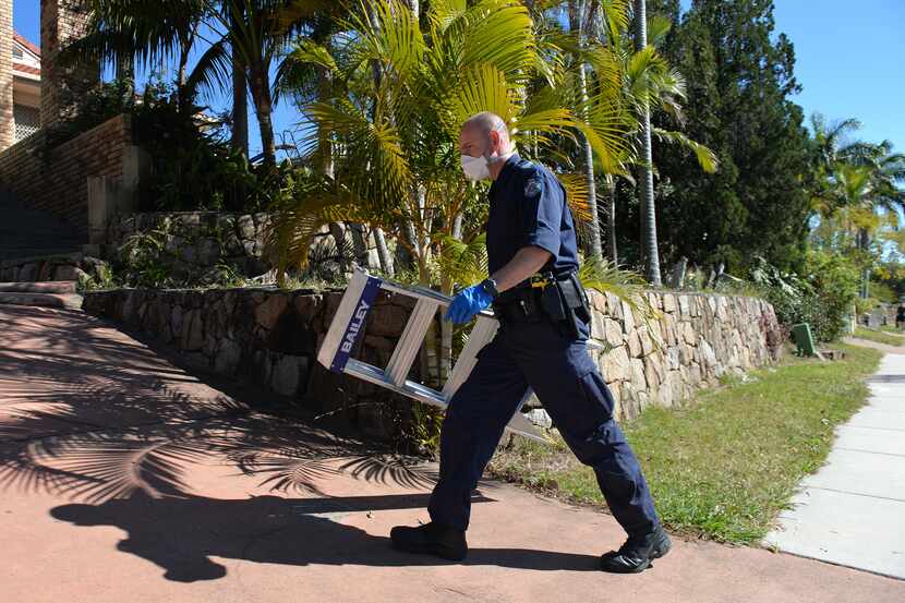 A police officer searched a house in Mount Gravatt, Brisbane on Thursday. Australian police...