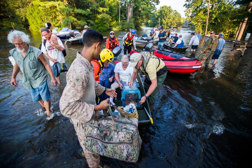 Marines and members of a swift water rescue task force from Tampa, Florida prepare rescue...