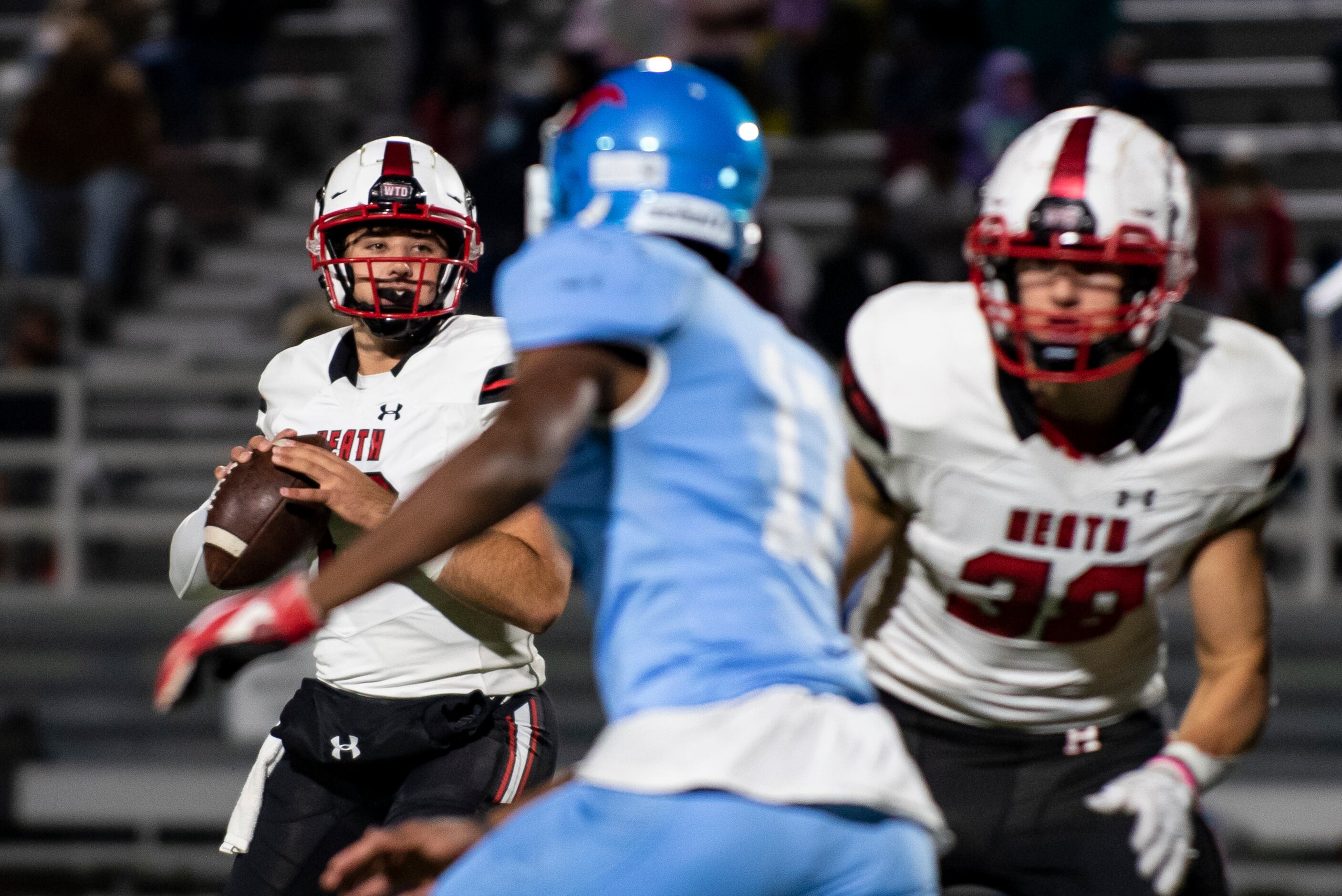 Heath senior Josh Hoover (17) looks for an open receiver during a District 10-6A game...