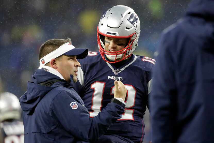 New England Patriots offensive coordinator Josh McDaniels, left, speaks to quarterback Tom...