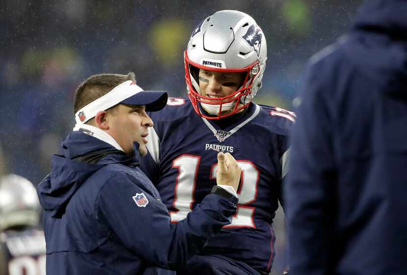 New England Patriots offensive coordinator Josh McDaniels, left, speaks to quarterback Tom...
