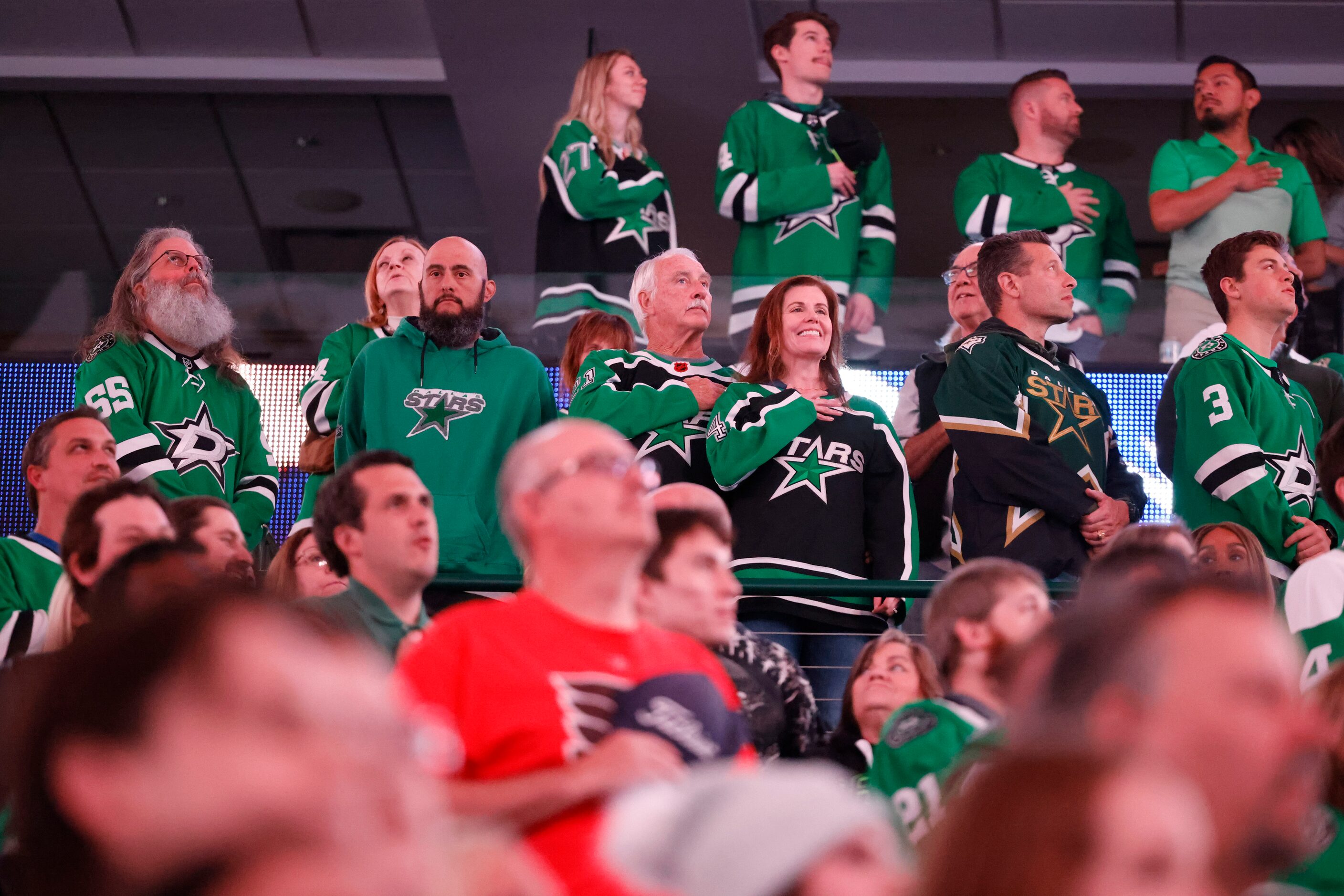 Dallas Stars fans stand for the National Anthem ahead of an an NHL hockey game against...