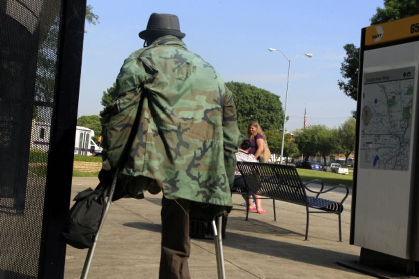 A man walks to a bus stop after leaving Parkland Memorial Hospital. Under a...