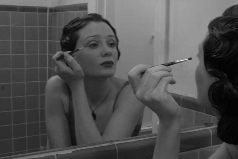 Singer-songwriter Kristy Kruger looks into the mirror while putting on makeup.