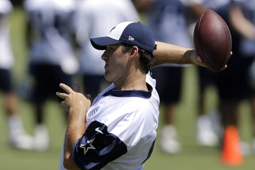 Dallas Cowboys quarterback Tony Romo (9) passes as he participates in wide receivers drills...