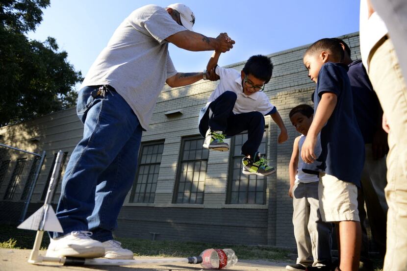 Employee John Sanchez helped Jaiden Martinez, 6, jump on a Coca Cola bottle to release a...