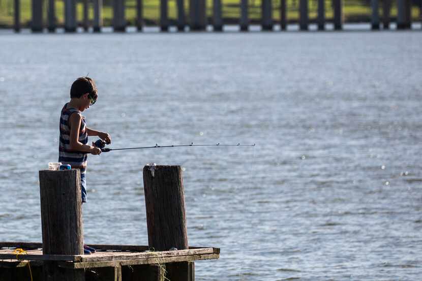 Jovanni Ledezma, 7, fishes from a pier at John Paul Jones Park along Lake Ray Hubbard in...