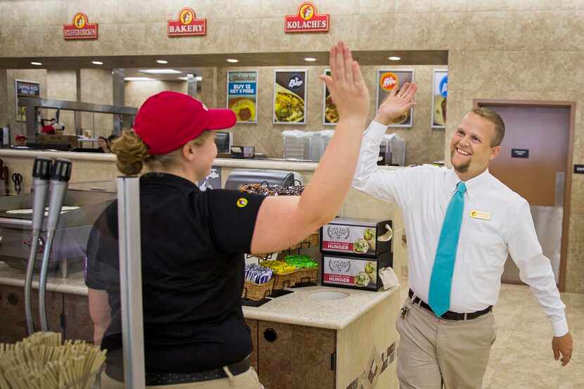 
Buc-ee’s general manager Josh Smith high-fives trainer Katie Francis as employees put the...