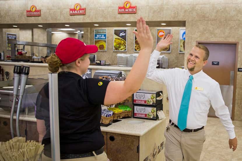 
Buc-ee’s general manager Josh Smith high-fives trainer Katie Francis as employees put the...