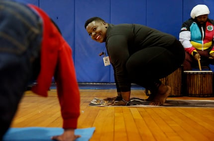 Ebony Smith, founder of Yoga N Da Hood, leds a yoga class to children in DISD's after-school...