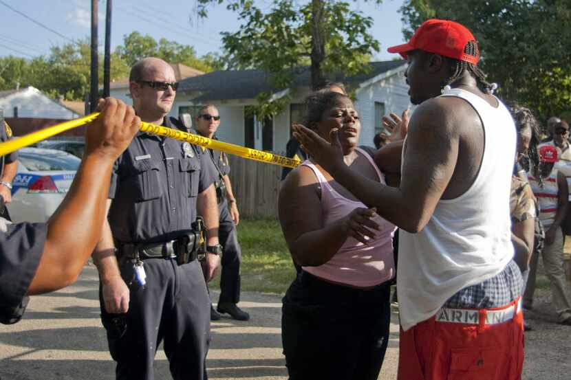 Veronica Williams tries to restrain Raymon Bradford from arguing with police along a...