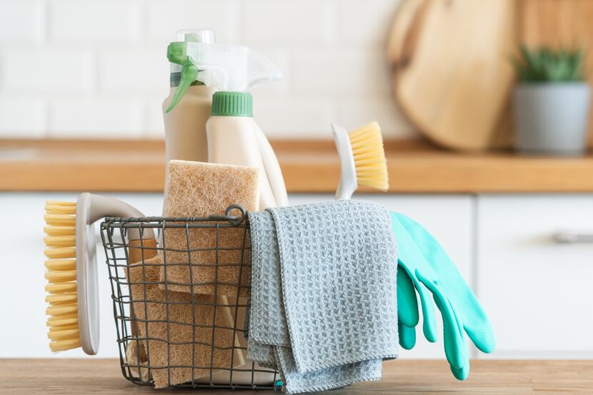 Basket of cleaning supplies on a kitchen counter
