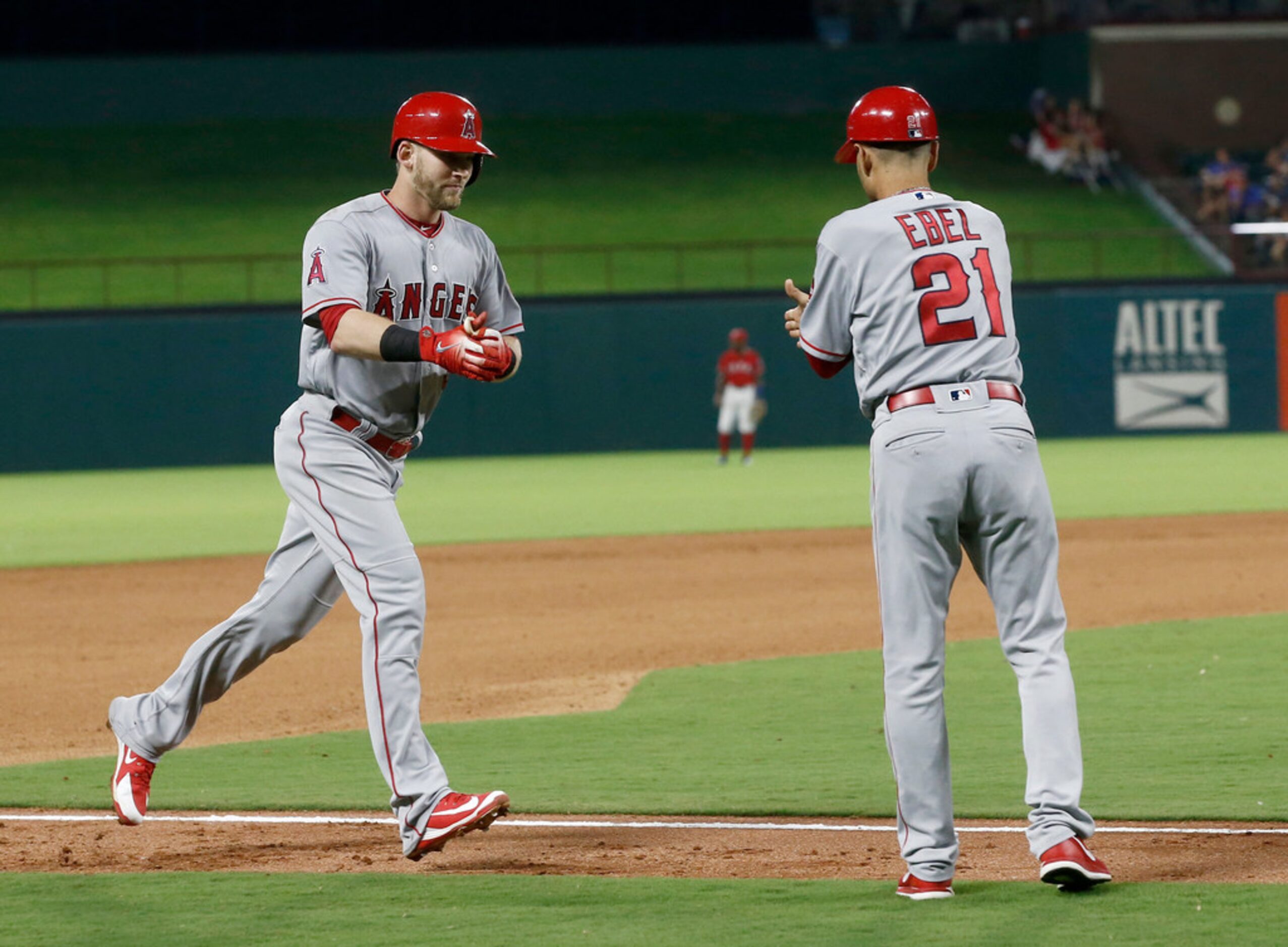 Los Angeles Angels' Taylor Ward is congratulated by this base coach Dino Ebel after he hit a...