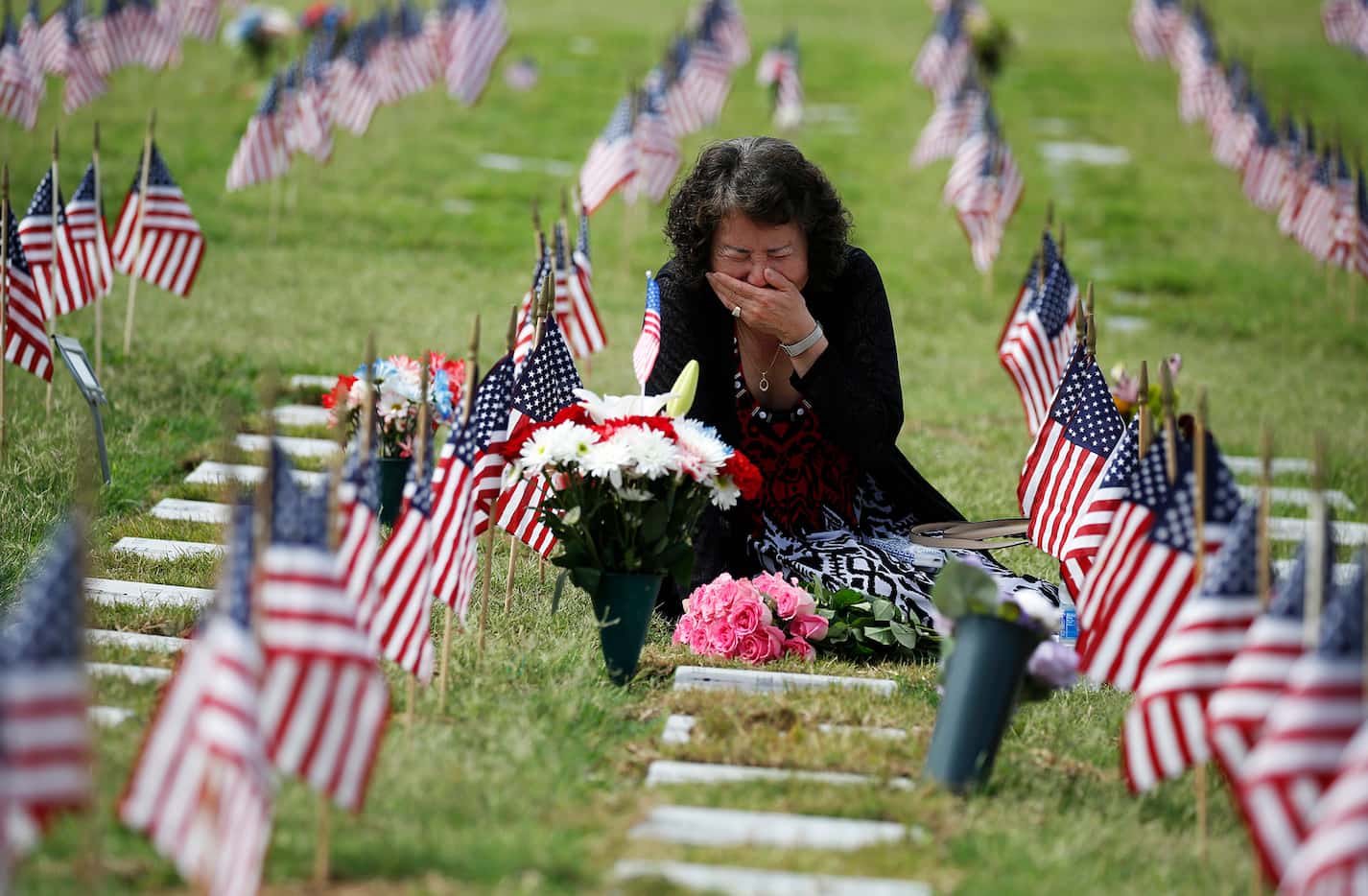 Una Pemberton of Wichita Falls cries at the grave of her son, Clem J. Strait III, who served...