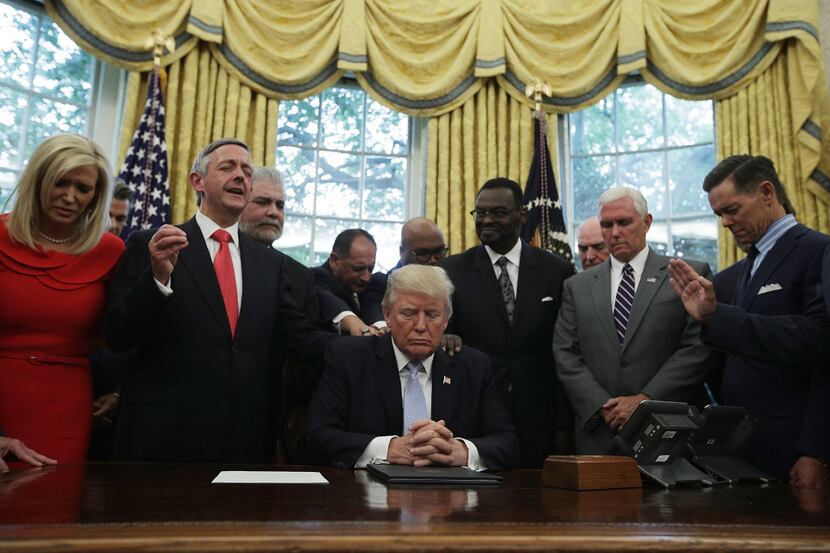 President Donald Trump, Vice President Mike Pence and faith leaders say a prayer during the...