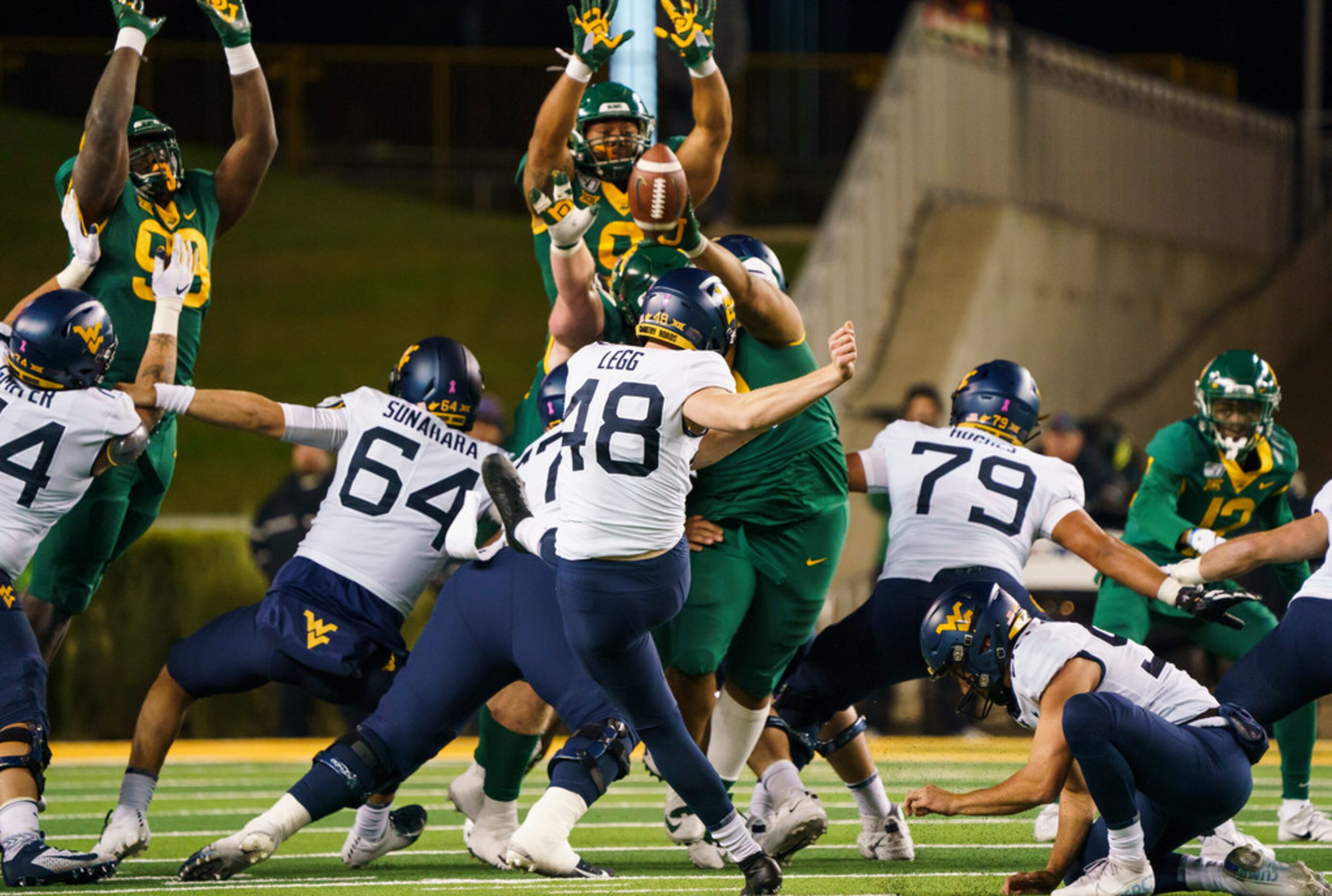 Baylor defensive tackle Bravvion Roy (99) blocks a field goal attempt by West Virginia place...